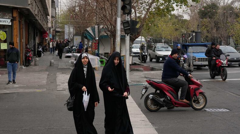 Women cross an intersection in downtown Tehran, Iran, Thursday, Jan. 15, 2026. (AP Photo/Vahid Salemi)