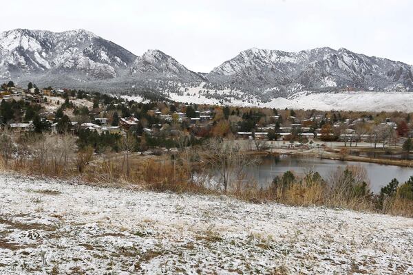 FILE - The Flatirons mountain formation lies dusted white after a night of light snowfall, in Boulder, Colo., on Nov. 17, 2015. (AP Photo/Brennan Linsley)