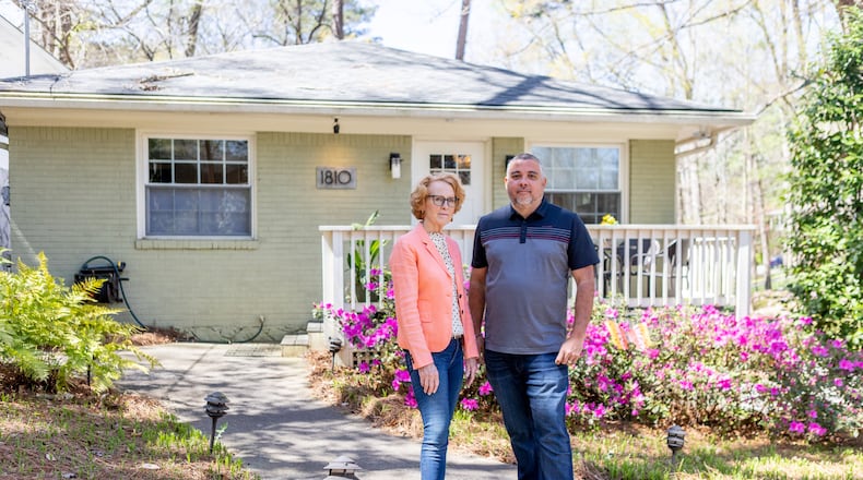 Rich Munroe and Kathie McClure, president and vice president of the Atlanta Metro Short Term Rental Alliance, pose for a photo in front of a rental home owned by McClure in the Piedmont Heights neighborhood on Friday. (Photo/Jenn Finch)