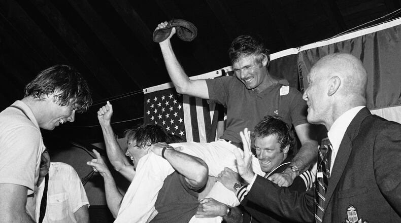 FILE - Ted Turner, center, is carried off by his crew following a news conference after his vessel Courageous won the Americas Cup sailing race, Sept. 19, 1977, in Newport, R.I. At right is Bill Ficker, skipper of cup winner Intrepid in 1970. (AP Photo/J. Walter Green, File)
