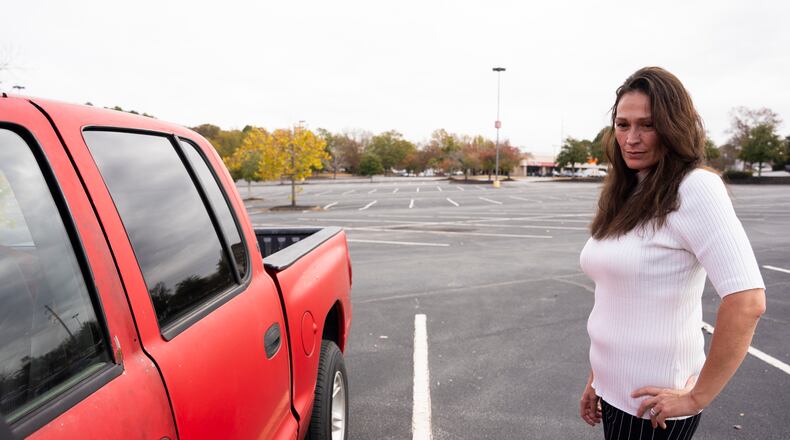 Rebekah Wilson said she was scammed out of $4,000 she paid for a down payment for a car from a program that claimed to be a nonprofit that helps adults in recovery obtain reliable vehicles. She never received the promised vehicle and still relies on her old red truck seen here in a parking lot outside an Athens shopping mall. (Olivia Bowdoin for The Atlanta Journal-Constitution)