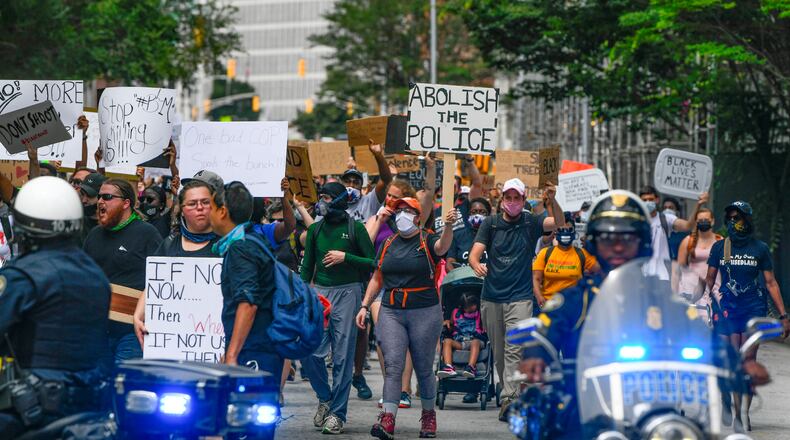 A group of demonstrators marches down Pryor Street, including one with a sign calling for the abolition of police, as they approach Atlanta City Police officers Saturday, June 6, 2020 (Photo: John Amis for The Atlanta Journal-Constitution)