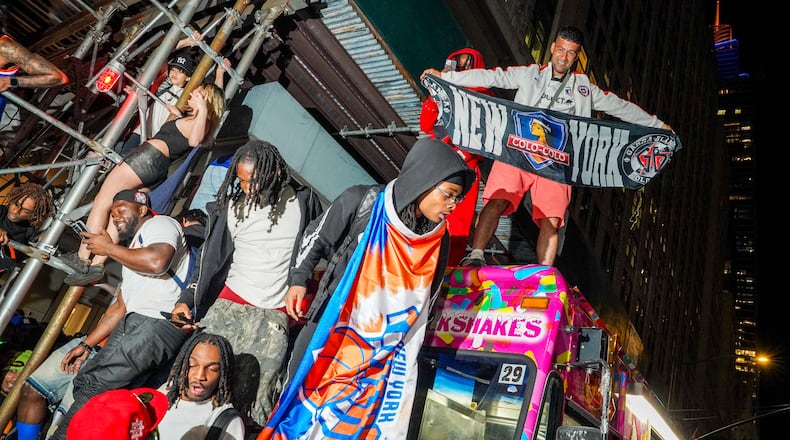 New York Knicks fans celebrate on the street outside of a watch party in Bryant Park for Game 3 of the NBA Finals basketball series between the Knicks and the San Antonio Spurs, Monday, June 8, 2026, in New York. (AP Photo/Ryan Murphy)