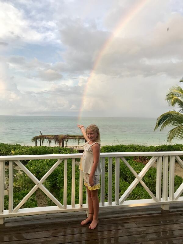Nancy Adams sent this picture of her granddaughter, Peyton Koetje, holding the rainbow in Kamalame Cay, Bahamas.  "As you can see from the wet deck, the
rains had just stopped.  With all the rain we have had in Atlanta, it is good to remember that the rainbow is the sign of God's promise to never again flood the entire world. (Genesis 9:15)," she wrote.