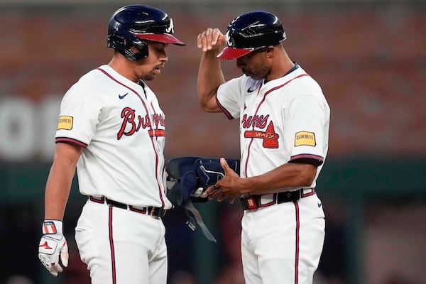Braves phenom Drake Baldwin (left) celebrates one of his three RBI hits with first base coach Tom Goodwin.