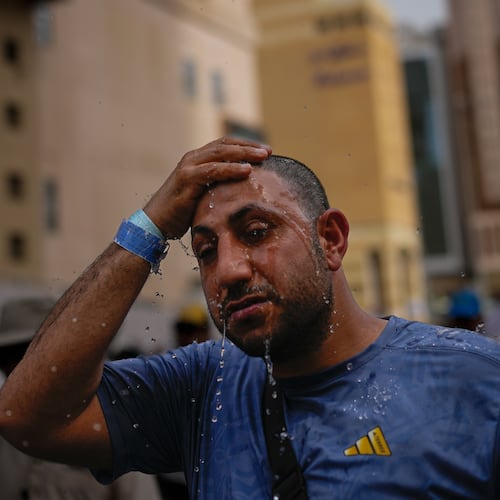 A Muslim pilgrim splashes water over his head too cool down outside the Grand Mosque during the annual hajj pilgrimage at the holy city of Mecca, Saudi Arabia, Sunday, May 24, 2026. (AP Photo/Altaf Qadri)