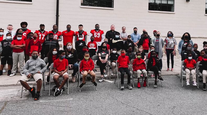The students from Downtown Academy couldn't all fit in a photo with Georgia football players Lewis Cine (16), Nakobe Dean (17), Kearis Jackson (10), receivers coach Cortez Hankton, Jake Camarda (90) and Jamaree Salyer (69) when they dropped off a check for $100,000 on Thursday. The money was the proceeds from Saturday's G-Day Intrasquad game, which will be attended by more the 20,000 fans on Saturday, April 17, 2021. (Photo by UGA Athletics)