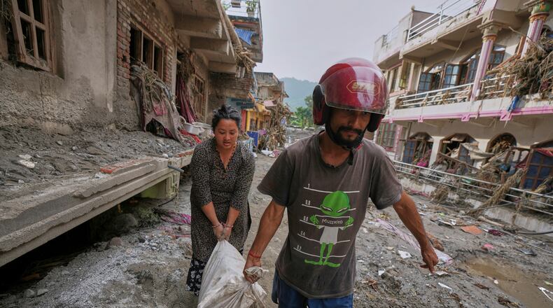 Residents salvage their belongings from damaged houses after flash flooding in the Devighat area of Nuwakot district in Nepal, Friday, Aug. 28, 2026. (AP Photo/Rajesh Kumar Singh)