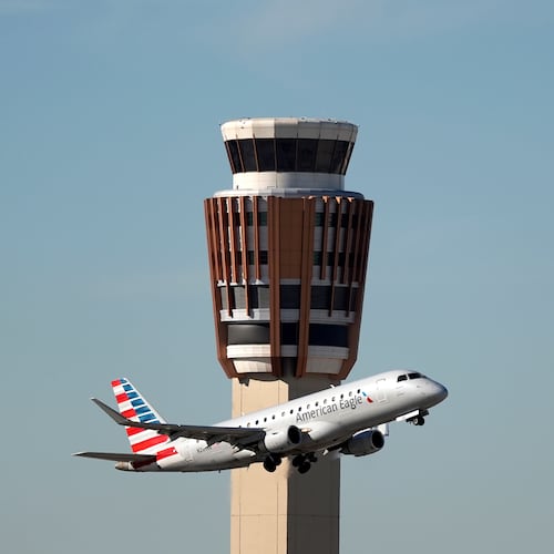 An American Airlines American Eagle jet flies past the air traffic control tower at Phoenix Sky Harbor International Airport Saturday, Nov. 8, 2025, in Phoenix. (AP Photo/Ross D. Franklin)
