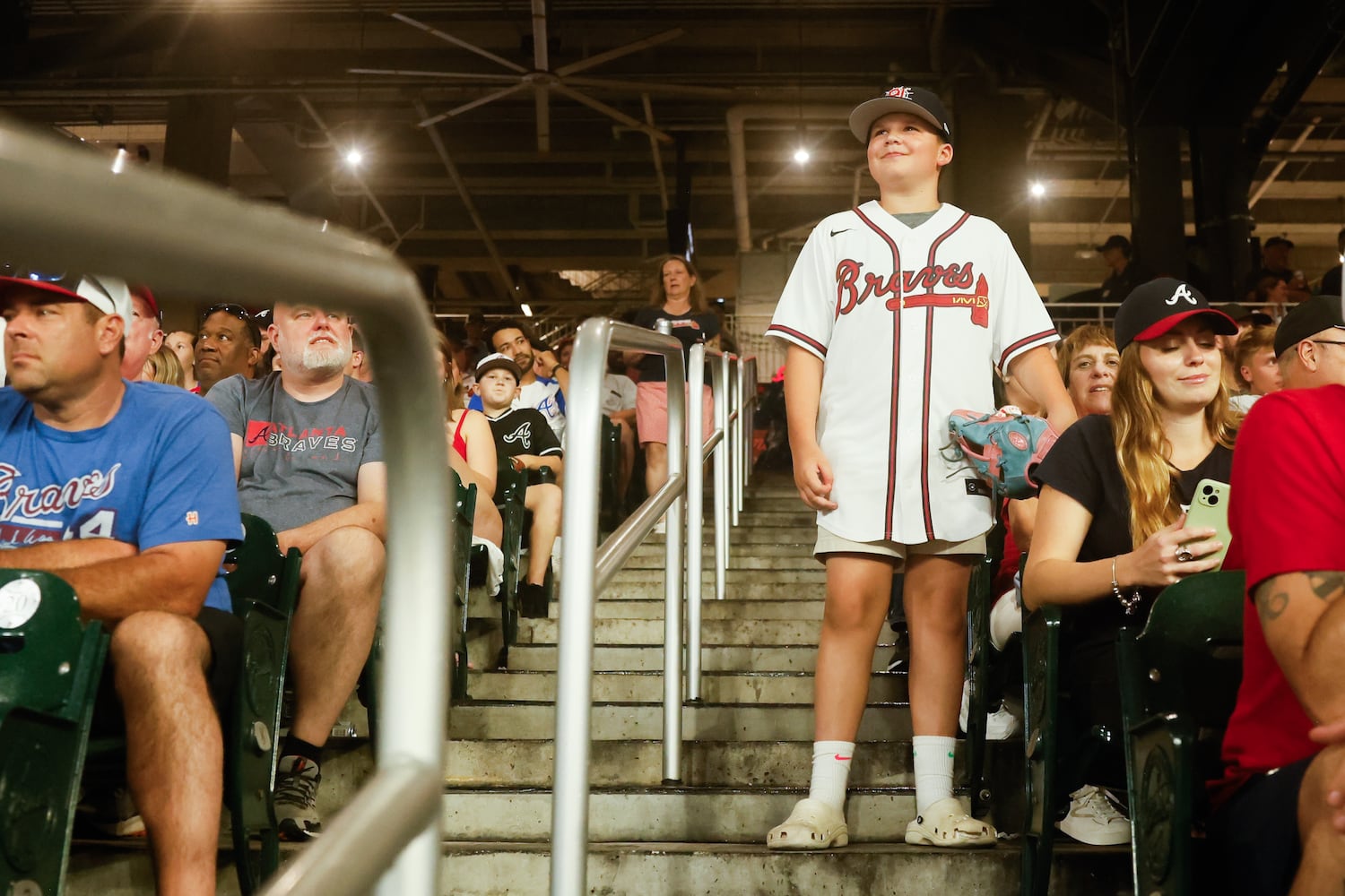 A fan watches the Braves take on the Phillies at Truist Park on Friday, June 27, 2025, in Atlanta. (Abbey Cutrer/AJC)