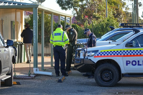 Police officers gather in Beacon, Western Australia, Friday, July 11, 2025, as they prepare to search for missing German backpacker Carolina Wilga. (ABC News via AP)