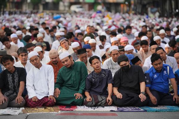 Muslims perform Eid al-Adha prayer on a street in Jakarta, Indonesia, Friday, June 6, 2025. (AP Photo/Dita Alangkara)