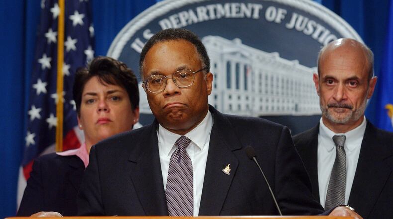Deputy Attorney General Larry Thompson, center, pauses during a news conference at Department of Justice in Washington in this 2002 file photo. AP/Stephen J. Boitano