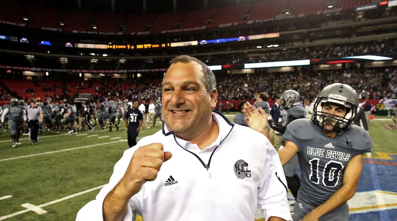 As time expired, Norcross coach Keith Maloof (with kicker Joseph Mahfood in the background) is all smiles as he heads toward midfield.