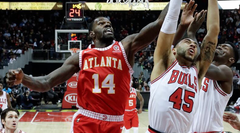 Atlanta Hawks center Dewayne Dedmon (14) battles Chicago Bulls forward Denzel Valentine (45) as he drives to the basket during the first half of an NBA basketball game Saturday, Jan. 20, 2018, in Atlanta. (AP Photo/John Bazemore)