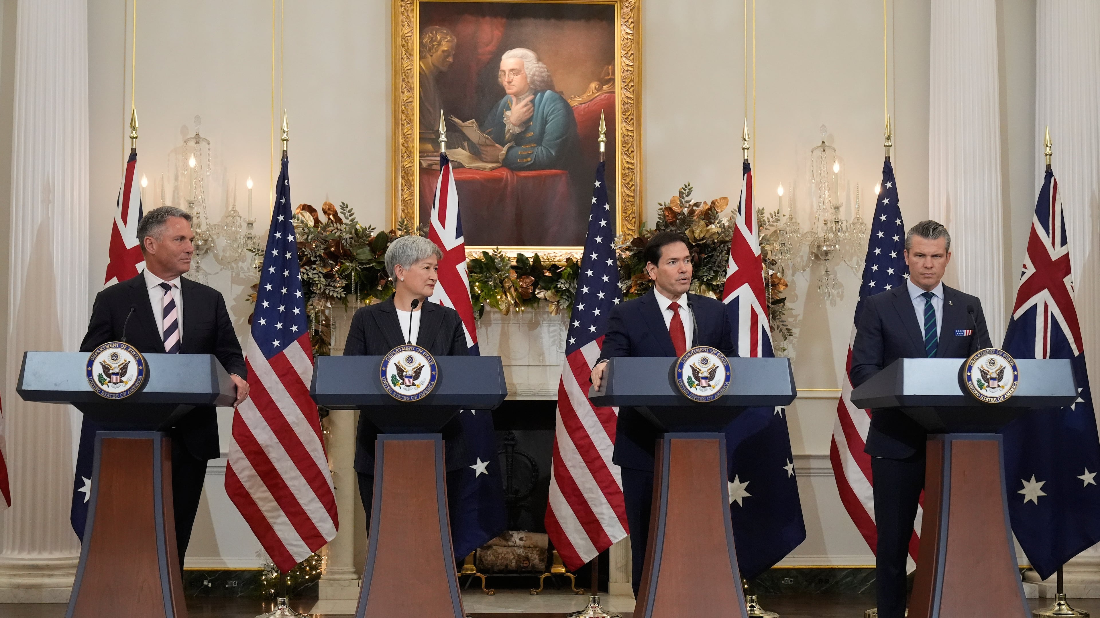 Secretary of State Marco Rubio speaks as Australia's Deputy Prime Minister and Defense Minister Richard Marles, Australia's Foreign Minister Penny Wong and Defense Secretary Pete Hegseth listen at the State Department, Monday, Dec. 8, 2025, in Washington. (AP Photo/Mark Schiefelbein)