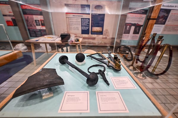 A display featuring objects found in 2021 alongside the 19 Revolutionary War cannons from the Savannah River. (Sarah Peacock for the AJC)