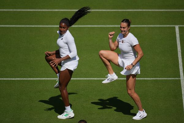 Aryna Sabalenka of Belarus, right, and Coco Gauff of United States dance during a practice session ahead of the Wimbledon Championships in London, Friday, June 27, 2025. (AP Photo/Kin Cheung)