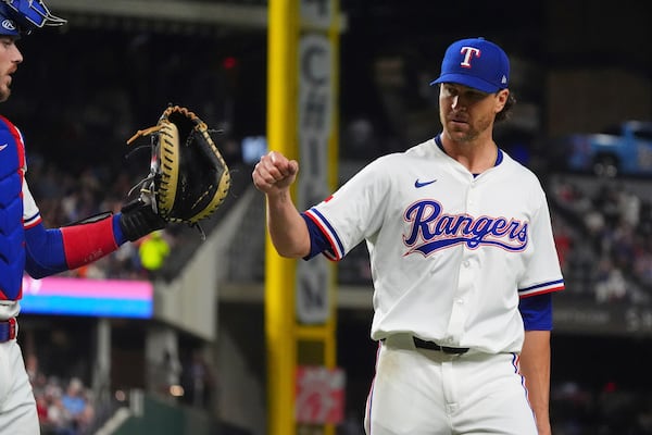 Texas Rangers starting pitcher Jacob deGrom, right, reaches out to teammate catcher Jonah Heim after the final out ending the seventh inning of a baseball game against the Houston Astros, Thursday, May 15, 2025, in Arlington, Texas. (AP Photo/LM Otero)