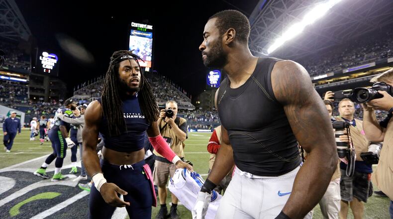 Seattle Seahawks cornerback Richard Sherman, left, and Detroit Lions wide receiver Calvin Johnson, right, swap jerseys after the Seahawks beat the Lions 13-10 in an NFL football game, Monday, Oct. 5, 2015, in Seattle. (AP Photo/Elaine Thompson)