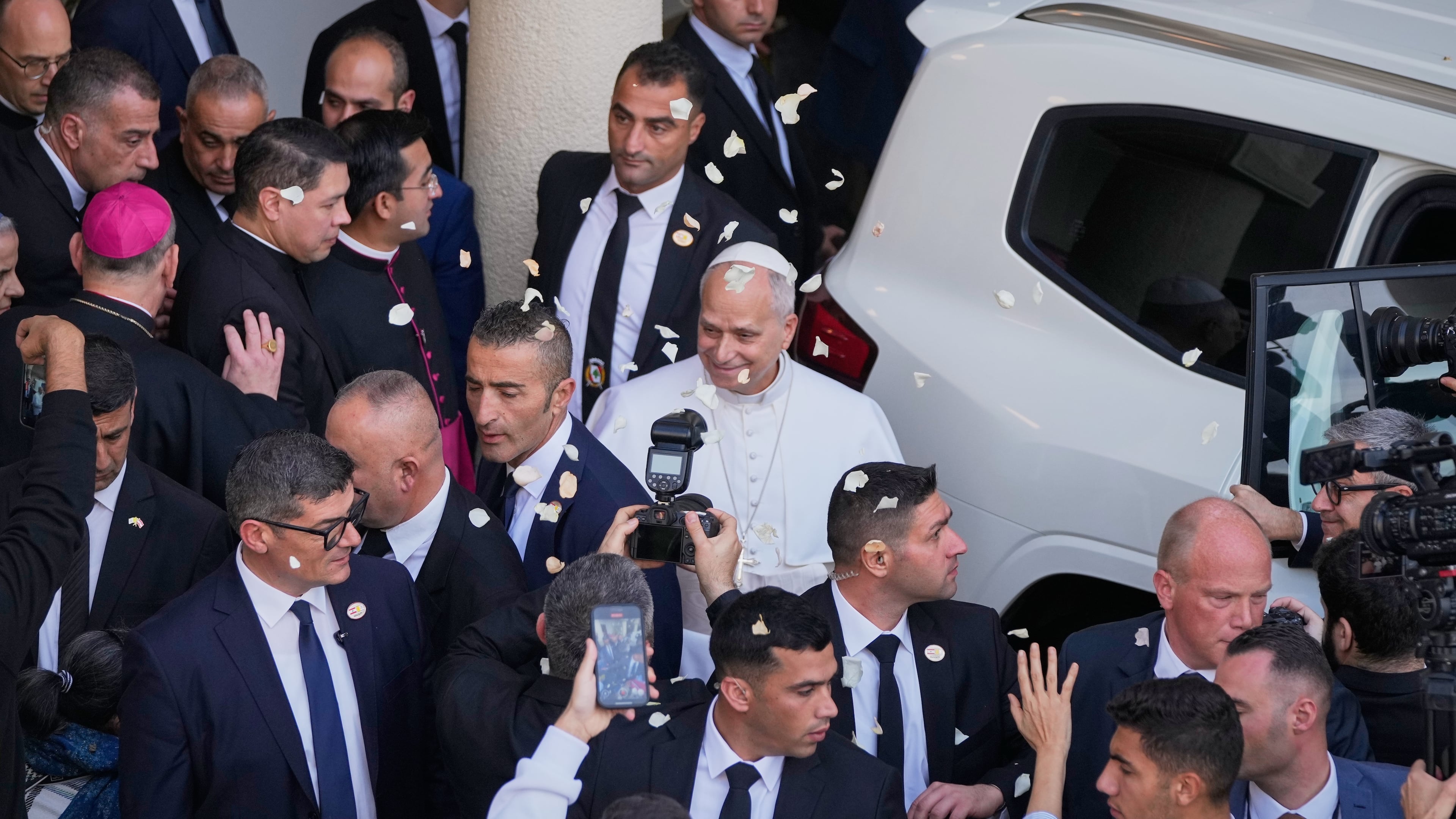 Rose petals are scattered to Pope Leo XIV as he leaves after visiting the Psychiatric Hospital of the Cross in the town of Jal el-Dib, north of Beirut, Lebanon, Tuesday, Dec. 2, 2025. (AP Photo/Hassan Ammar)