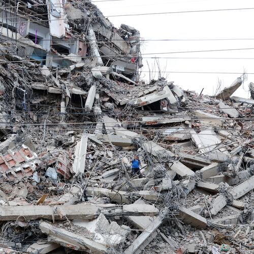A man walks among the rubble of a building that collapsed in earthquakes the previous day in La Guaira, Venezuela, Thursday, June 25, 2026. (AP Photo/Pedro Mattey)
