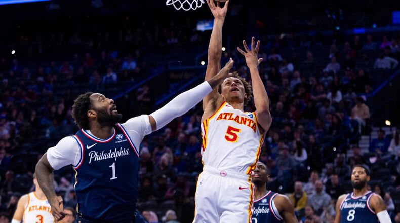 Atlanta Hawks' Dyson Daniels, right, shoots the ball with Philadelphia 76ers' Andre Drummond defending during the first half of an NBA basketball game Sunday, Nov. 30, 2025, in Philadelphia. (AP Photo/Chris Szagola)