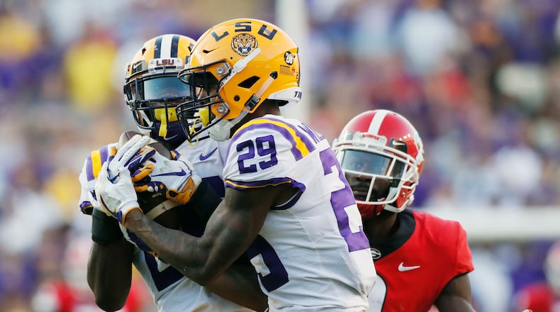 10/13/18 - Baton Rouge -  LSU Tigers safety John Battle (26), with assistance from  LSU Tigers cornerback Greedy Williams (29),  intercepts a  Georgia Bulldogs quarterback Jake Fromm pass intended for Georgia Bulldogs wide receiver Jeremiah Holloman (9) late in the 4th quarter to seal the Tigers victory.  The Tigers won 36-16.   The University of Georgia Bulldogs played the Louisiana State University Tigers in a NCAA college football game Saturday, October 13, 2018, at Tiger Stadium in Baton Rouge, LA.    BOB ANDRES / BANDRES@AJC.COM
