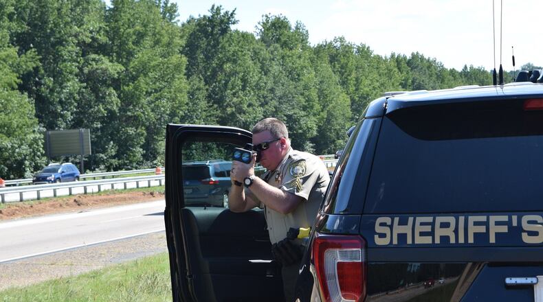 Forsyth County Sheriff’s Department Corporal Brian Chatham utilizes a laser speed gun to enforce the speed limit on the southbound lanes of Ga. route 400 near exit 16. Marty Farrell for the AJC