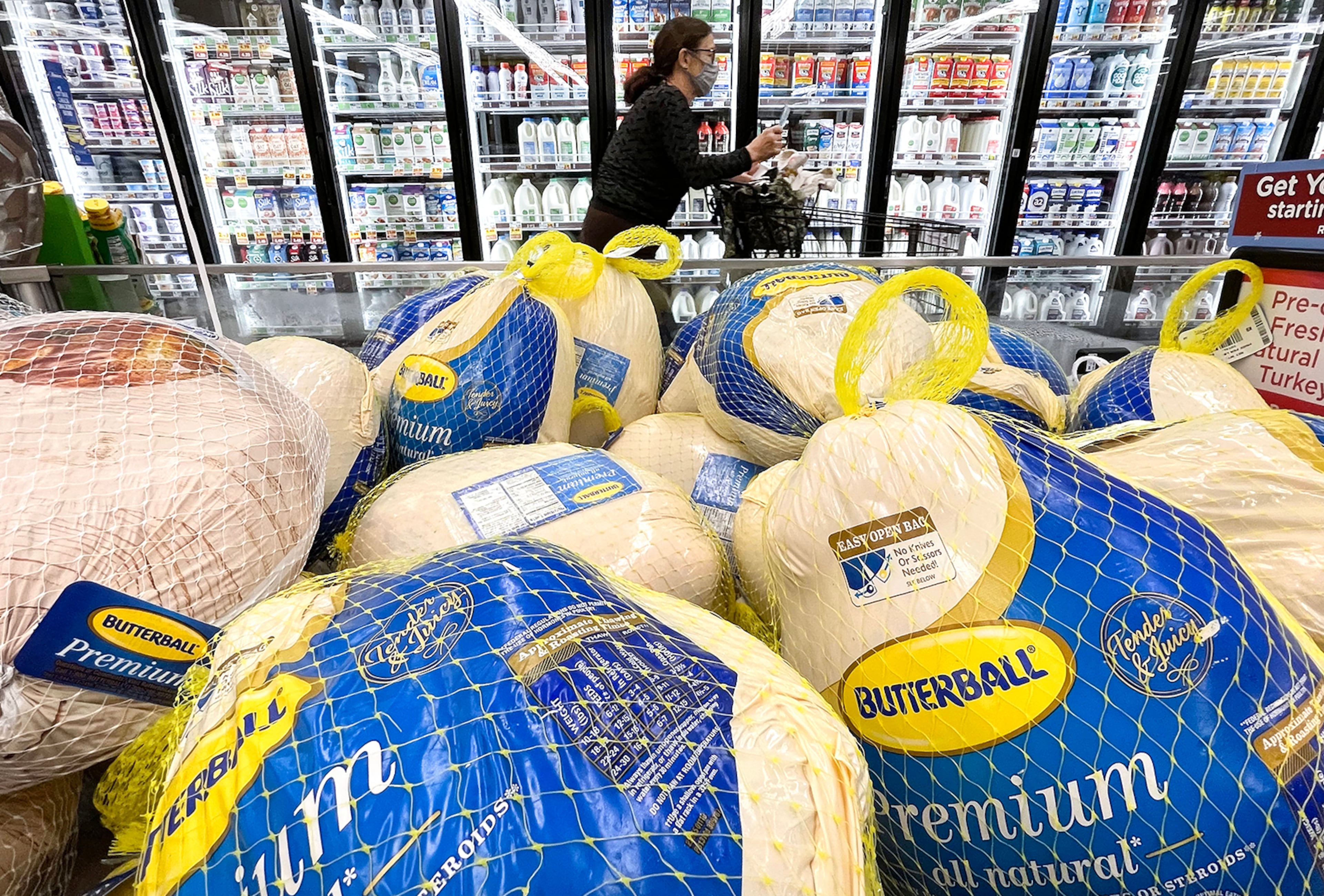A shopper walks past turkeys displayed for sale in a grocery store ahead of the Thanksgiving holiday in Los Angeles. Grocery stores and other retailers could be discounting turkeys to lure more customers into their doors. (Mario Tama/Getty Images/TNS 2021)
