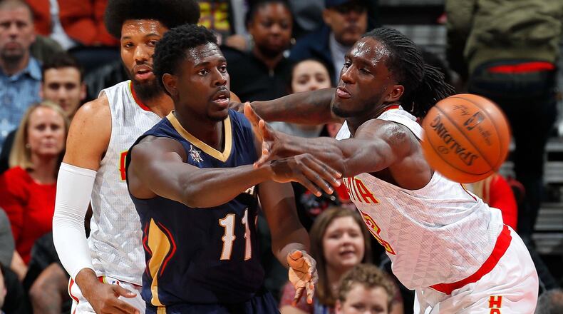 Jrue Holiday of the New Orleans Pelicans passes the ball against Taurean Prince (right)and DeAndre Bembry of the Atlanta Hawks at Philips Arena on November 22, 2016 in Atlanta, Georgia. (Photo by Kevin C. Cox/Getty Images)