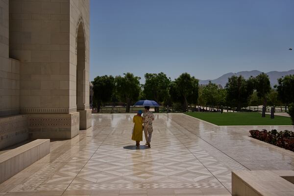 A couple walks through the courtyard of the Sultan Qaboos Grand Mosque in Muscat, Oman, Saturday, April 12, 2025. (AP Photo/ Fatima Shbair)