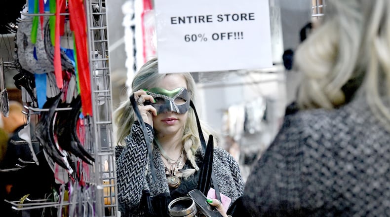 Lauren Donnelly tries on a costume eye mask during store closing sale at Eddie's Trick Shop in Marietta Square, Tuesday, February 6, 2024, in Marietta. Eddie’s Trick Shop, which sells and rents costumes and accessories and magic tricks, has been a Marietta staple since the mid-1970s. They announced on Feb. 2 they are closing down later this month. Currently, they are selling everything 60% off and a good portion of the store has already bene emptied. (Hyosub Shin / Hyosub.Shin@ajc.com)