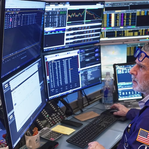 Trader John Romolo works on the floor of the New York Stock Exchange, Friday, Feb. 20, 2026. (AP Photo/Richard Drew)