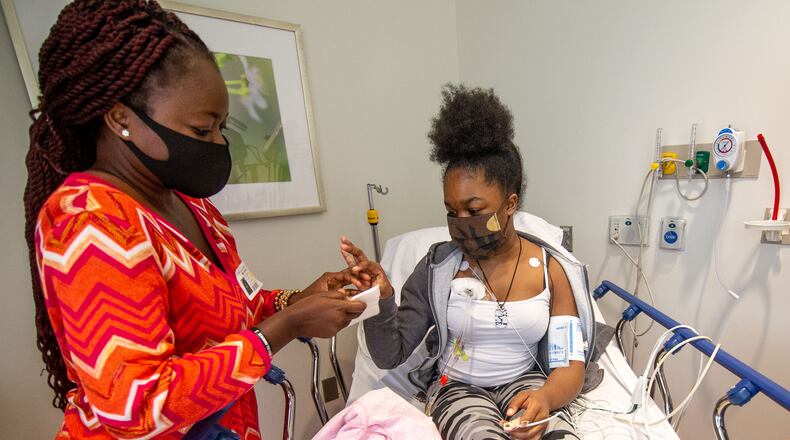 Mapillar Dahn talks with her daughter Khadeejah Tyler, 15, while she undergoes her sickle cell anemia treatment at the Scottish Rite Children's Hospital in Atlanta. STEVE SCHAEFER / SPECIAL TO THE AJC