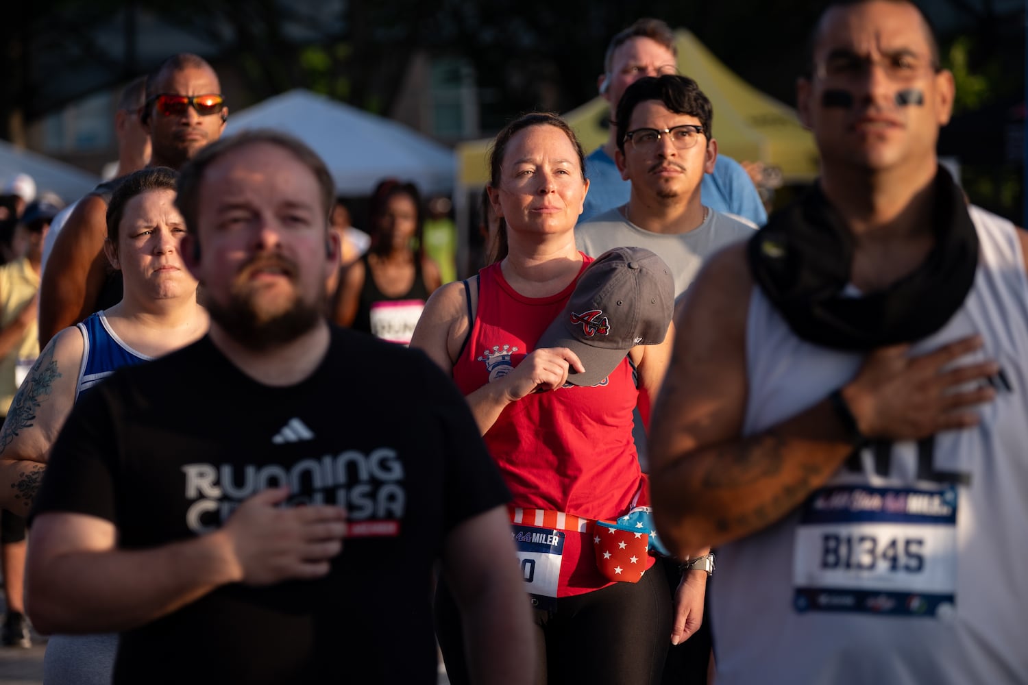 Erin Pesti listens to the National Anthem before the start of the MLB All-Star 4.4 Miler in Atlanta on Sunday, July 13, 2025.   Ben Gray for the Atlanta Journal-Constitution