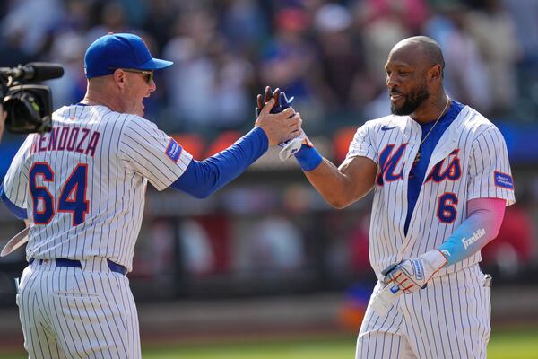 New York Mets manager Carlos Mendoza, left, celebrates with Starling Marte after he hit a walk-off RBI single in the 10th inning of a baseball game against the Philadelphia Phillies, Wednesday, April 23, 2025, in New York. (AP Photo/Seth Wenig)