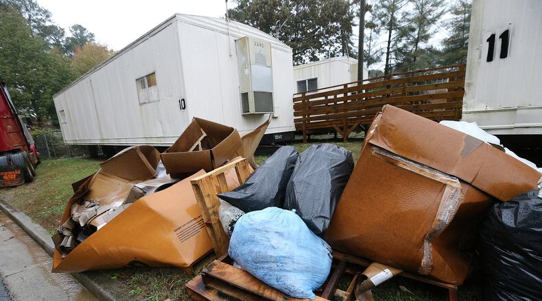 Bags of construction debris from school maintenance work sit stacked up behind classroom trailers at Dekalb County’s Dresden Elementary School on Monday, Nov. 12, 2018, in Chamblee. Curtis Compton/ccompton@ajc.com