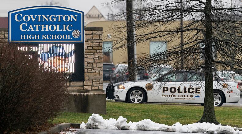 A police car sits at the entrance to Covington Catholic High School in Park Hills, Ky., Saturday, Jan 19, 2019. A diocese in Kentucky apologized Saturday after videos emerged showing students from the Catholic boys' high school mocking Native Americans outside the Lincoln Memorial on Friday after a rally in Washington. (AP Photo/Bryan Woolston)