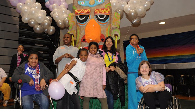 Several East Cobb Middle School students take a parting shot with the tiki display at the Adaptive PE Dance at Kennesaw Mountain High School in 2012.