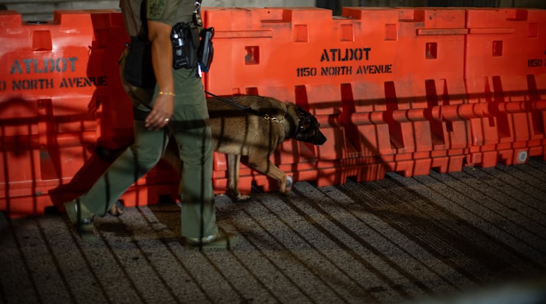 A deputy walks a barricade erected before dawn outside the Fulton County Courthouse in Atlanta, on Aug. 15, 2023. Police said Thursday that they were investigating online threats against the grand jurors who voted this week to indict Donald Trump and 18 others; the jurors’ names are public record under Georgia law. (Hilary Swift/The New York Times)
