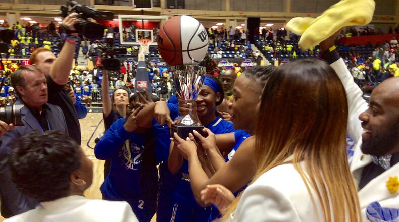 Americus-Sumter players and coaches receive the championship trophy after defeating Troup 66-52 in the Class AAAA girls final on Friday, March 6, 2020, at the Macon Centreplex.