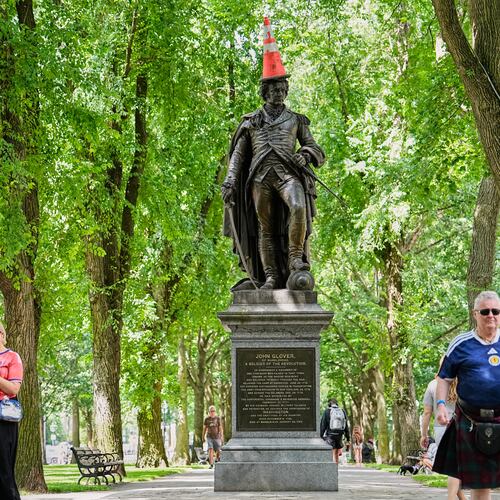 Scottish fans passing a statue of the revolutionary John Glover, humorously decorated with a traffic cone, in a park in Boston, Mass., ahead of the World Cup Group C soccer match between Scotland and Morocco, Friday, June 19, 2026. (AP Photo/Martin Meissner)