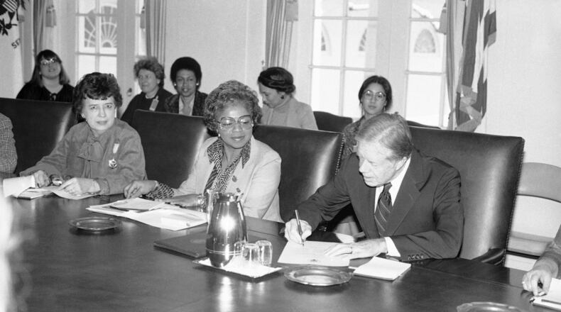 President Jimmy Carter signs document at the White House in Washington on Feb. 28, 1980 proclaiming March 2-8 "National Women’s History Week." To the president’s right are: Jane Pratt, president, Girls’ Clubs of America; and Gloria Johnson, treasurer, Coalition of Labor Union Women. Those in background are unidentified. (AP Photo/Barry Thumma)