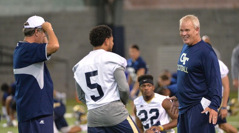 Georgia Tech quarterback Justin Thomas (5), chatting Friday on the first day of practice with safeties coach Andy McCollum, is one of five scholarship quarterbacks on the roster, unusual depth for the Yellow Jackets. HYOSUB SHIN / HSHIN@AJC.COM