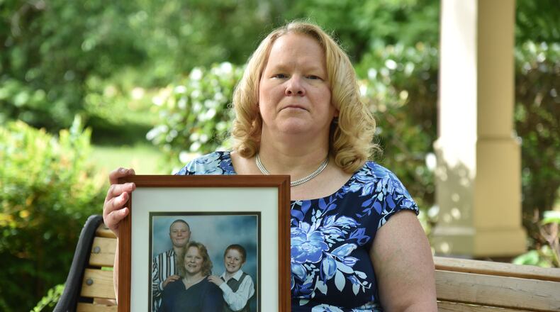 May 3, 2017 Norcross - Debra Baldwin holds a family photograph that was taken with her two sons Austin (left) and Nicholas on Wednesday, May 3, 2017. Debra Baldwin is the mother of a former inmate who survived a suicide attempt. An inmate's mother made several phone calls to the Georgia State Prison at Reidsville to alert them she feared her son would try to kill himself. A counselor spoke with the inmate who was have auditory and visual hallucinations. The scheduled an appointment to have him evaluated the next week. That same day he tried to kill himself. He survived but is comatose and now a ward of the state for the rest of his life. HYOSUB SHIN / HSHIN@AJC.COM