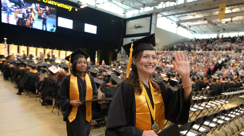 Nicole Baldwin waves to to supporters after receiving her bachelor of science degree at Kennesaw State University’s commencement in May. On Dec. 15, Kennesaw State will hold its first commencement since combining with Southern Polytechnic State University in January. More than 2,500 students are expected to graduate. BRANT SANDERLIN/BSANDERLIN@AJC.COM