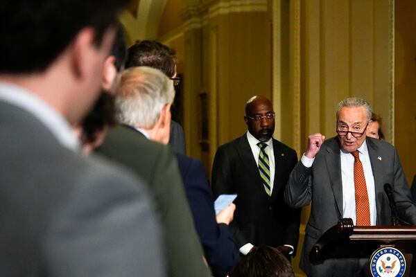 Senate Minority Leader Chuck Schumer, D-N.Y., flanked by U.S. Sen. Raphael Warnock, D-Ga., spoke to reporters at the U.S. Capitol on Tuesday.