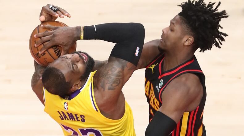 Foul on the play: Hawks forward Cam Reddish hits LeBron James with a hard foul during the early portion of Monday's Hawks-Lakers matchup at State Farm Arena.