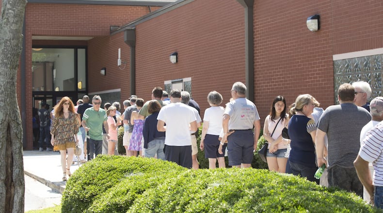 The wait for early voting Saturday at the East Cobb Government Service Center in Cobb County at times stretched to an hour, with a line that stretched around the corner of the building. CHAD RHYM/AJC